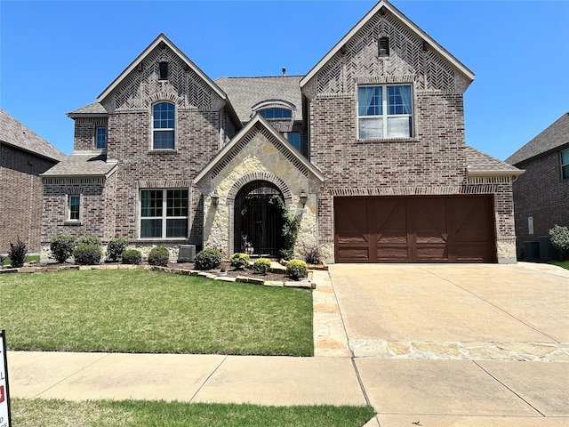 13818 Mammoth Cave Ln, Frisco, TX 75035 - french country inspired facade featuring brick siding, a front lawn, driveway, a garage, and central AC