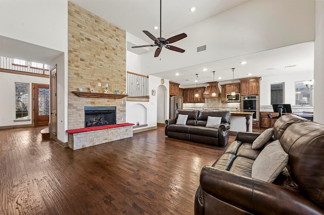 13818 Mammoth Cave Ln, Frisco, TX 75035 - living room with a towering ceiling, a fireplace, dark wood-type flooring, ceiling fan, and recessed lighting