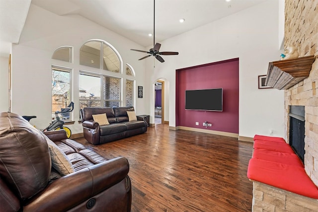 13818 Mammoth Cave Ln, Frisco, TX 75035 - living area with arched walkways, wood finished floors, high vaulted ceiling, a fireplace, and ceiling fan
