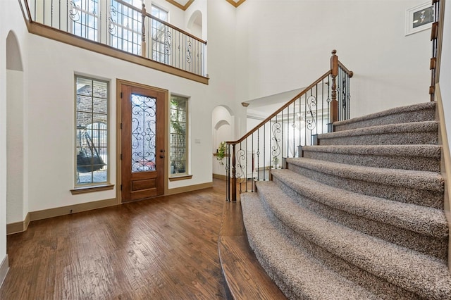 13818 Mammoth Cave Ln, Frisco, TX 75035 - entryway with hardwood / wood-style floors, arched walkways, stairway, baseboards, and a high ceiling