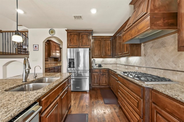 13818 Mammoth Cave Ln, Frisco, TX 75035 - kitchen featuring stainless steel appliances, a sink, premium range hood, dark wood-style floors, and light stone counters