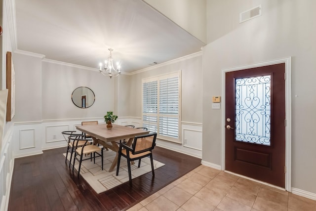 851 Carolina Way, Lantana, TX 76226 - dining space with a chandelier, a decorative wall, ornamental molding, a wainscoted wall, and wood finished floors