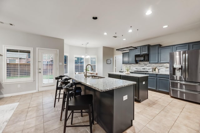 851 Carolina Way, Lantana, TX 76226 - kitchen with stainless steel refrigerator with ice dispenser, a center island with sink, a sink, black microwave, and light tile patterned floors