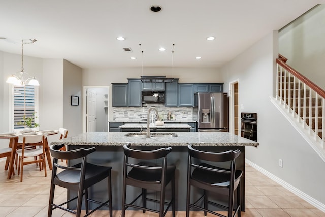 851 Carolina Way, Lantana, TX 76226 - kitchen with stainless steel fridge, black microwave, a center island with sink, light tile patterned flooring, and backsplash