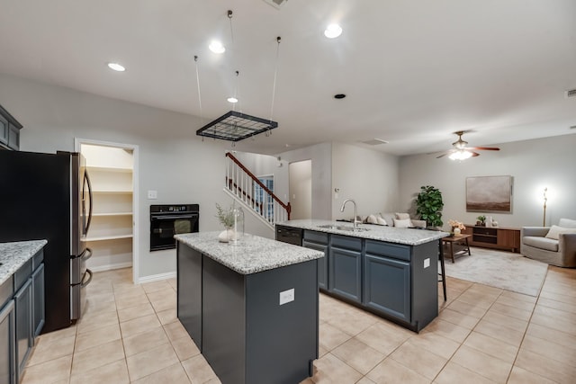 851 Carolina Way, Lantana, TX 76226 - kitchen featuring a kitchen island with sink, black oven, freestanding refrigerator, open floor plan, and a sink