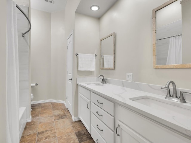 1308 River Birch Ln, Carrollton, TX 75007 - full bathroom featuring stone finish floors, toilet, double vanity, and baseboards