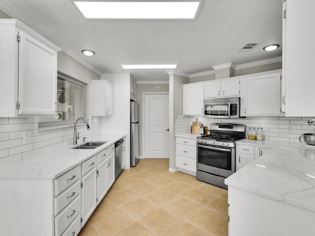 1308 River Birch Ln, Carrollton, TX 75007 - kitchen featuring stainless steel appliances, a sink, white cabinets, backsplash, and crown molding