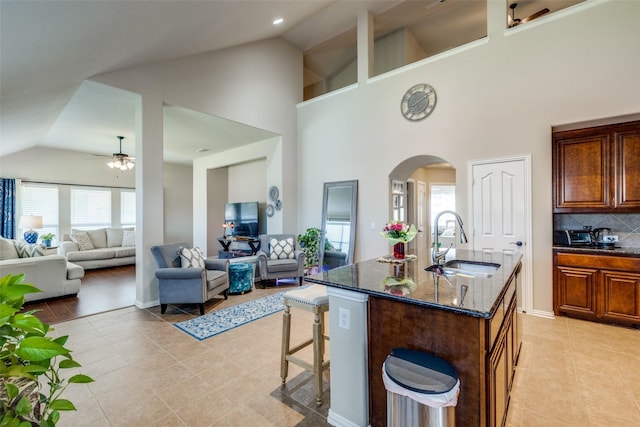 4806 Ashbury Ln, Mansfield, TX 76063 - kitchen with a sink, a ceiling fan, arched walkways, light tile patterned flooring, and high vaulted ceiling