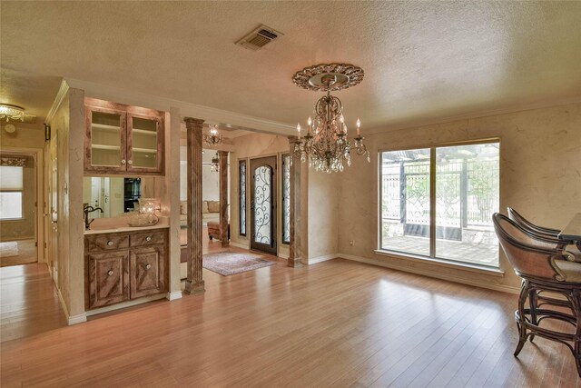 4009 Scenic Way, Granbury, TX 76049 - unfurnished dining area featuring ornamental molding, light wood finished floors, a chandelier, a textured ceiling, and baseboards