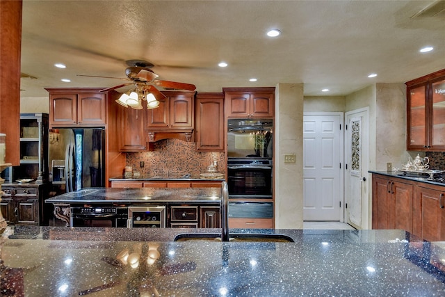 4009 Scenic Way, Granbury, TX 76049 - kitchen featuring black appliances, a ceiling fan, dark stone countertops, beverage cooler, and decorative backsplash
