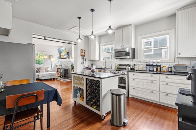 2236 Alston Ave, Fort Worth, TX 76110 - kitchen featuring stainless steel appliances, dark countertops, tasteful backsplash, and white cabinets