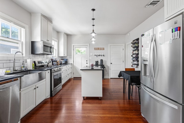 2236 Alston Ave, Fort Worth, TX 76110 - kitchen featuring stainless steel appliances, dark countertops, dark wood finished floors, decorative backsplash, and plenty of natural light