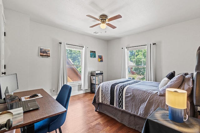 2236 Alston Ave, Fort Worth, TX 76110 - bedroom with multiple windows, wood finished floors, a desk, and ceiling fan