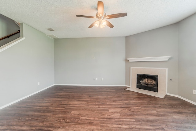 1010 Hanover Dr, Forney, TX 75126 - unfurnished living room featuring ceiling fan, wood finished floors, a textured ceiling, a tile fireplace, and baseboards