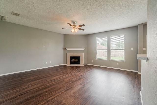 1010 Hanover Dr, Forney, TX 75126 - unfurnished living room with a tile fireplace, a ceiling fan, dark wood finished floors, a textured ceiling, and baseboards