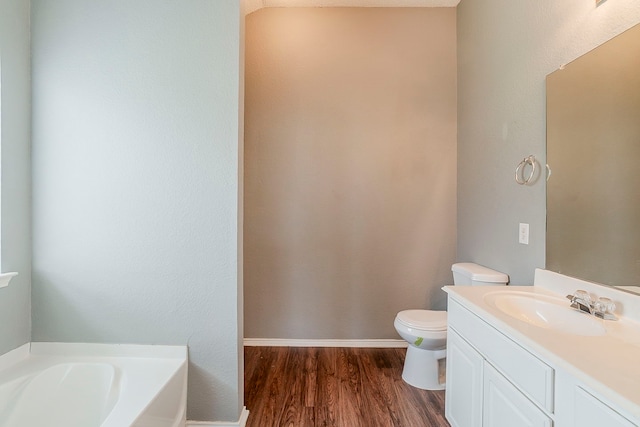 1010 Hanover Dr, Forney, TX 75126 - bathroom with a garden tub, wood finished floors, toilet, and vanity