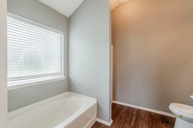 1010 Hanover Dr, Forney, TX 75126 - full bath featuring a garden tub, wood finished floors, toilet, baseboards, and lofted ceiling