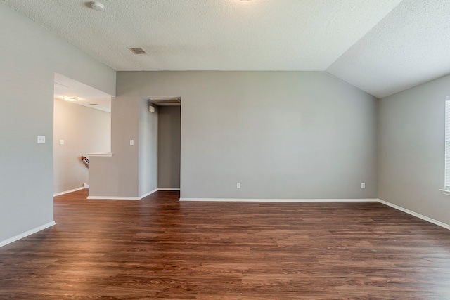 1010 Hanover Dr, Forney, TX 75126 - empty room featuring vaulted ceiling, dark wood-style flooring, a textured ceiling, and baseboards