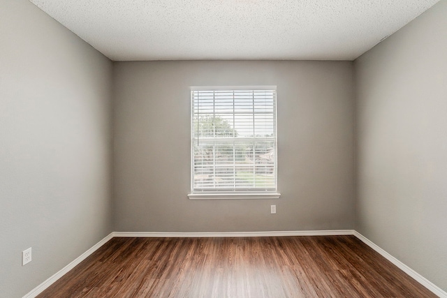 1010 Hanover Dr, Forney, TX 75126 - spare room featuring dark wood-style floors, baseboards, and a textured ceiling