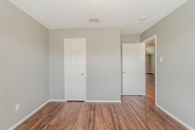 1010 Hanover Dr, Forney, TX 75126 - unfurnished bedroom with wood finished floors, baseboards, and a textured ceiling