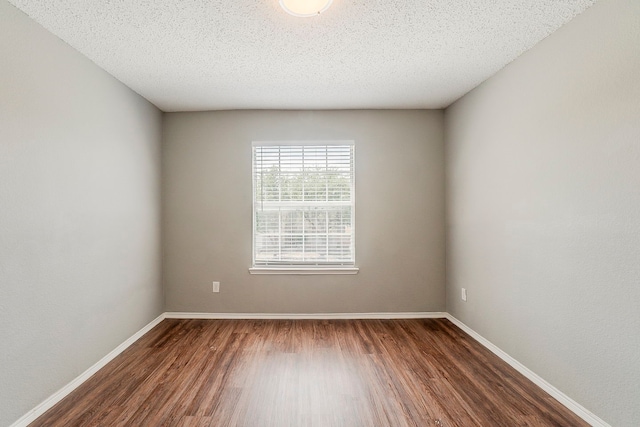 1010 Hanover Dr, Forney, TX 75126 - unfurnished room with dark wood-style flooring, baseboards, and a textured ceiling