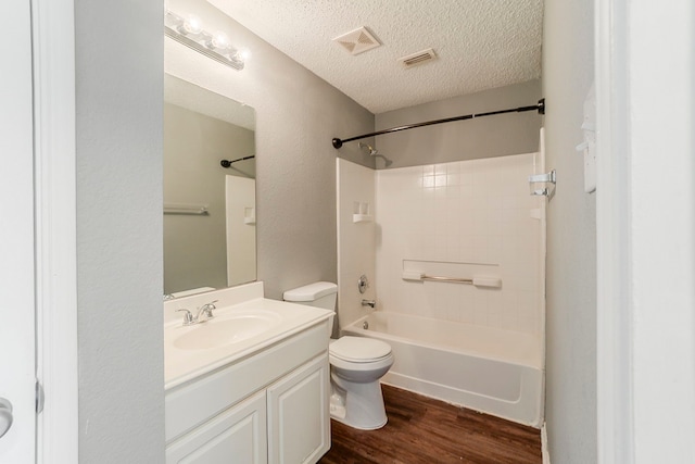 1010 Hanover Dr, Forney, TX 75126 - bathroom with toilet, wood finished floors, vanity, washtub / shower combination, and a textured ceiling