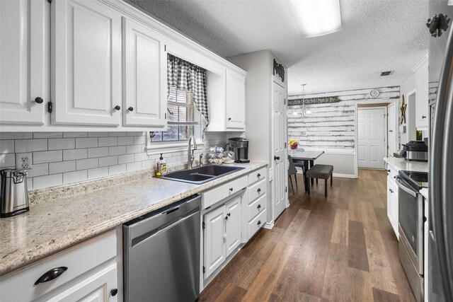 203 Marianne, Sulphur Springs, TX 75482 - kitchen with appliances with stainless steel finishes, a sink, white cabinets, dark wood-style flooring, and a textured ceiling