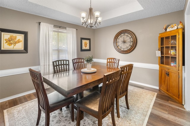 203 Marianne, Sulphur Springs, TX 75482 - dining space with light wood finished floors, a chandelier, baseboards, and a tray ceiling
