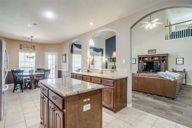 5040 Pallas Ct, Fort Worth, TX 76123 - kitchen with a kitchen island, ceiling fan, open floor plan, decorative light fixtures, and stainless steel refrigerator with ice dispenser