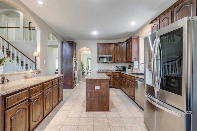 5040 Pallas Ct, Fort Worth, TX 76123 - kitchen featuring stainless steel appliances, arched walkways, recessed lighting, a kitchen island, and a sink