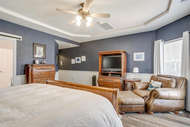 5040 Pallas Ct, Fort Worth, TX 76123 - bedroom featuring wood finished floors, a textured wall, a wainscoted wall, and ceiling fan