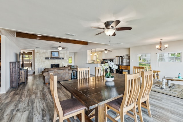 142 Peninsula Point Ter, Mabank, TX 75156 - dining space with a stone fireplace, wood finished floors, ceiling fan, and a chandelier