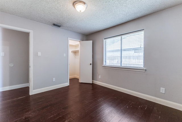 18609 Crownover Ct, Dallas, TX 75252 - unfurnished bedroom with a spacious closet, hardwood / wood-style floors, a textured ceiling, baseboards, and a closet