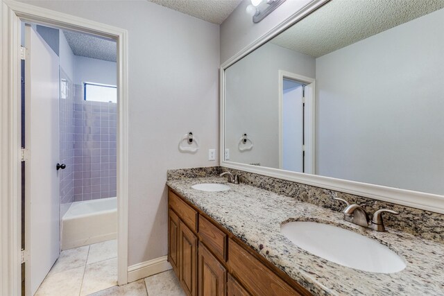 18609 Crownover Ct, Dallas, TX 75252 - bathroom with a textured ceiling, double vanity, tile patterned floors, and washtub / shower combination