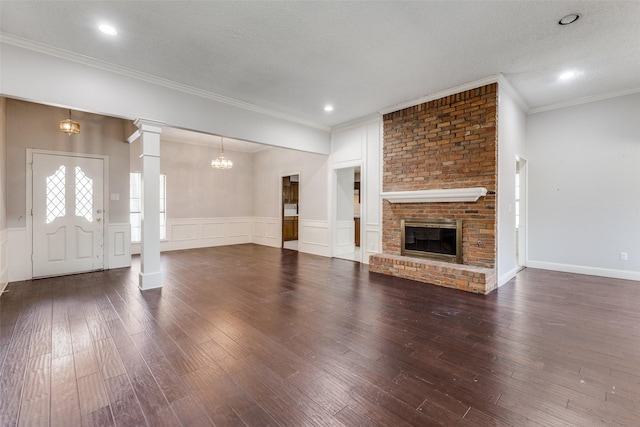 18609 Crownover Ct, Dallas, TX 75252 - unfurnished living room featuring hardwood / wood-style flooring, crown molding, a wainscoted wall, a decorative wall, and a brick fireplace