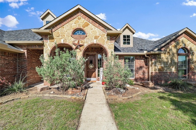 5142 Carlton Pkwy, Waxahachie, TX 75165 - view of front of house featuring stone siding, brick siding, a front lawn, and a shingled roof