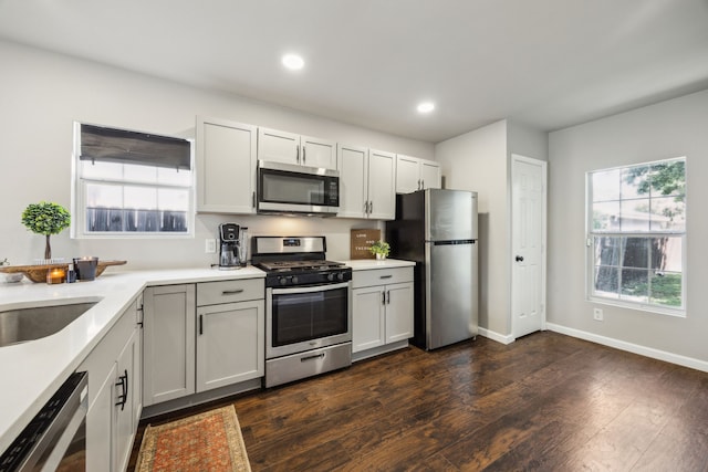 1215 Morrell Ave, Dallas, TX 75203 - kitchen featuring stainless steel appliances, light countertops, dark wood-type flooring, baseboards, and recessed lighting