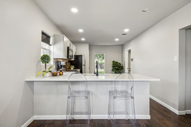 1215 Morrell Ave, Dallas, TX 75203 - kitchen with a peninsula, a sink, light countertops, recessed lighting, and white cabinetry