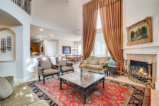 1113 Waterford Way, Allen, TX 75013 - living area featuring arched walkways, light tile patterned floors, a fireplace, a high ceiling, and a chandelier