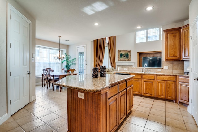 1113 Waterford Way, Allen, TX 75013 - kitchen featuring a sink, brown cabinetry, light tile patterned flooring, recessed lighting, and a kitchen island