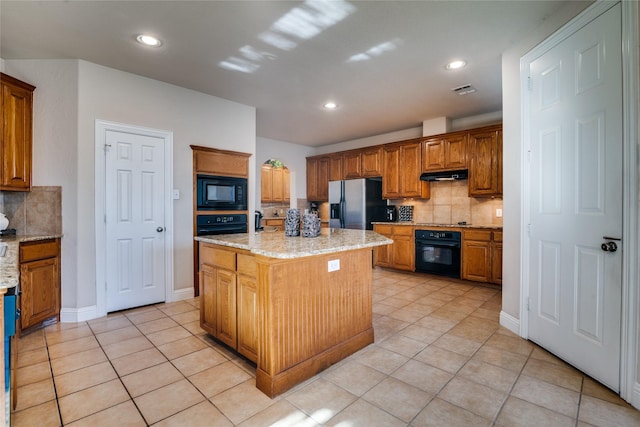 1113 Waterford Way, Allen, TX 75013 - kitchen with black appliances, under cabinet range hood, light tile patterned floors, decorative backsplash, and a kitchen island