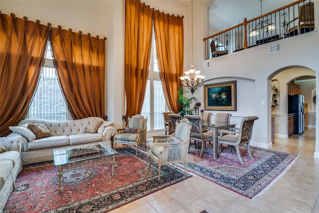 1113 Waterford Way, Allen, TX 75013 - living area featuring arched walkways, healthy amount of natural light, tile patterned flooring, a chandelier, and a towering ceiling