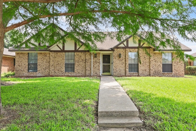 1646 Belltower Dr, Lewisville, TX 75067 - tudor house featuring a front lawn and brick siding