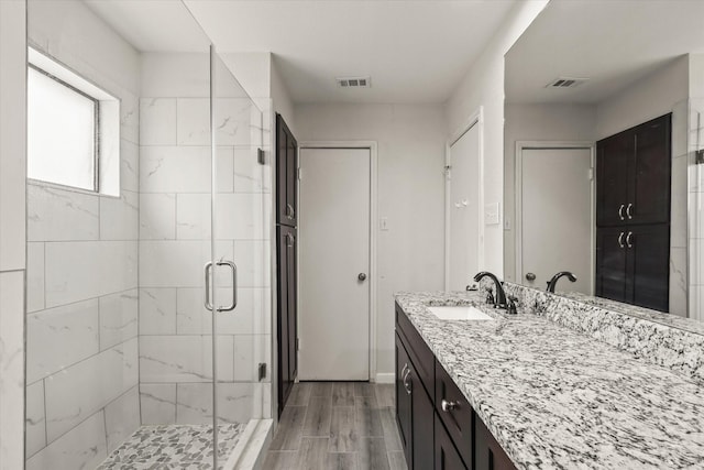 1646 Belltower Dr, Lewisville, TX 75067 - bathroom featuring a stall shower, vanity, wood tiled floors, and baseboards