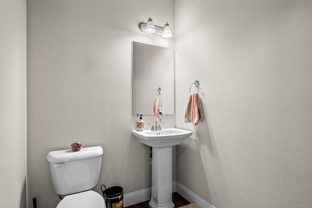 3657 Harebell Dr, Carrollton, TX 75007 - bathroom with toilet, wood finished floors, and a sink