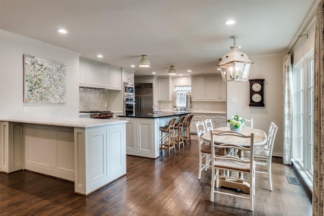 4560 Lorraine Ave, Highland Park, TX 75205 - kitchen with built in appliances, dark wood finished floors, recessed lighting, crown molding, and a breakfast bar