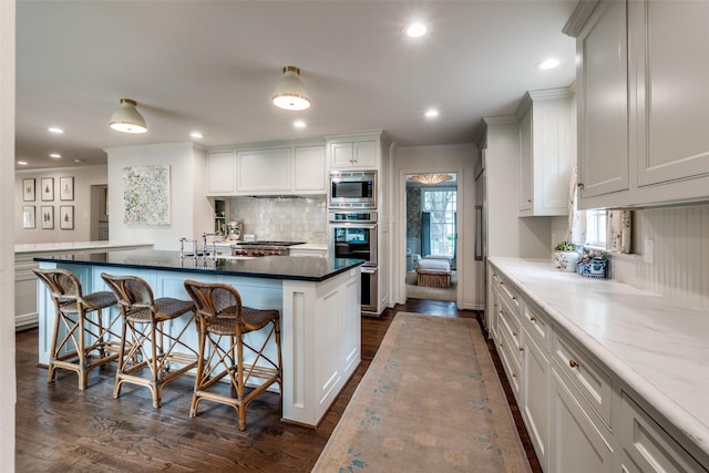 4560 Lorraine Ave, Highland Park, TX 75205 - kitchen featuring a kitchen breakfast bar, backsplash, ornamental molding, stainless steel appliances, and dark wood-type flooring