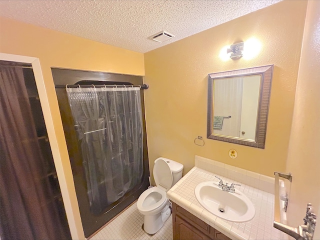 21363 Stevenson Rd, Frankston, TX 75763 - full bathroom featuring vanity, toilet, a textured ceiling, a shower with shower curtain, and tile patterned floors