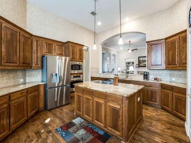 7805 Chapel View Dr, Mckinney, TX 75072 - kitchen featuring stainless steel appliances, arched walkways, ceiling fan, tasteful backsplash, and a kitchen island