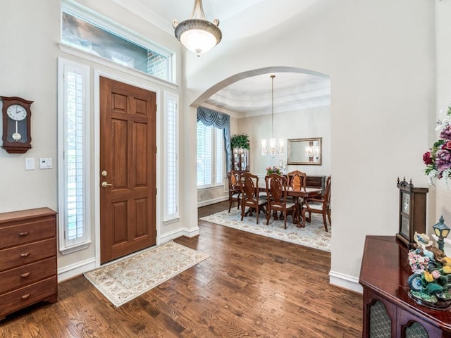 7805 Chapel View Dr, Mckinney, TX 75072 - foyer entrance featuring arched walkways, crown molding, dark wood-style flooring, a tray ceiling, and baseboards